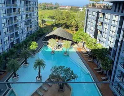an overhead view of a swimming pool with palm trees and buildings at Citygate Kamala Resort & Residence in Kamala Beach