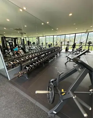 a gym with a lot of treadmills and machines at Citygate Kamala Resort & Residence in Kamala Beach