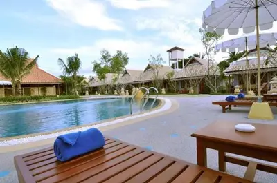a swimming pool with a wooden table and an umbrella at Ongsantiphap villa resort in Ban Klang