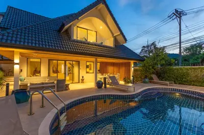 a house with a swimming pool in front of a house at Brand new, designer furnishing, hot tub, gym, pool V98 in Rawai Beach