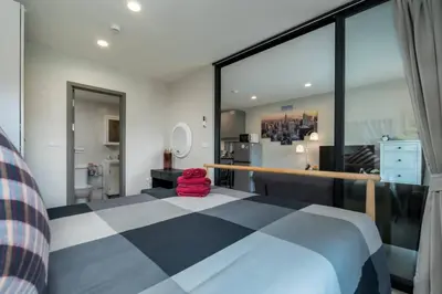 a bedroom with a bed with a red stuffed animal on it at A1 The Title Nayang Стильная квартира in Nai Yang Beach