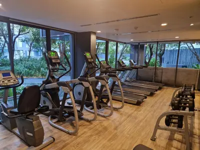 a gym with several treadmills and elliptical machines at The Deck Condo Patong 7th Fl Mountain View1 in Patong Beach