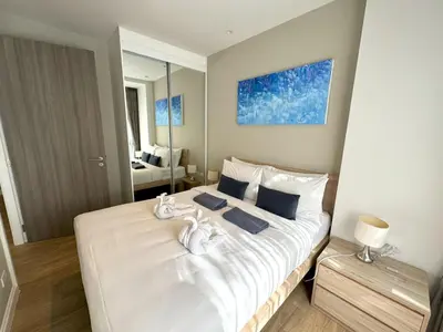 a bedroom with a white bed with towels on it at Modern 2br apartment near Bangtao beach in Bang Tao Beach
