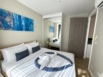 a bedroom with a large bed with towels on it at Modern 2br apartment near Bangtao beach in Bang Tao Beach