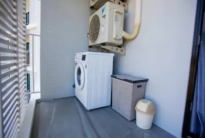 a laundry room with a washer and a washing machine at Title Rent Rawai in Rawai Beach