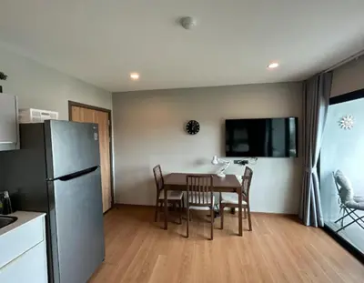 a kitchen and dining room with a table and a refrigerator at Title Rent Rawai in Rawai Beach