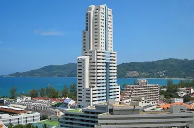 a tall white building in a city next to the water at Sea view apartment with jacuzzi at Patong Tower in Patong Beach