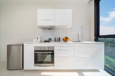 a kitchen with white appliances and a window at Sea & Mountain Views Apartment at VV Patong A603 in Patong Beach