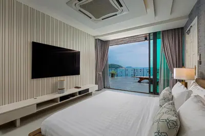 a hotel room with a bed and a large window at Villa W Luxury in Nai Harn Beach