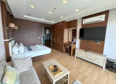 a hotel room with a bed and a tv at Spacious mountain view studio at Sea Sky 206 in Karon Beach