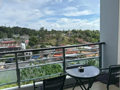a balcony with a table and chairs and a view at Spacious mountain view studio at Sea Sky 206 in Karon Beach