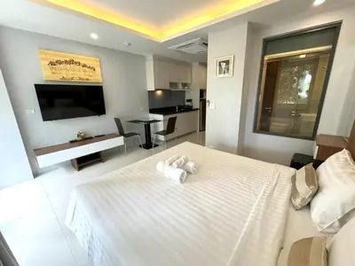 a bedroom with a white bed with towels on it at Peaceful Rawai studio with washer by Lofty in Rawai Beach