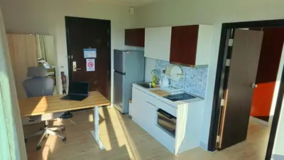 a kitchen with a desk and a laptop on a table at Stylish Apartment with Workspace 10 Minutes from the Beach for min 30 Day Stays in Phuket Town