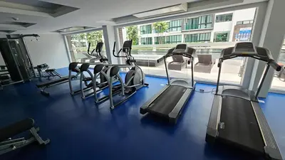 a gym with several treadmills and a large window at Stylish Apartment with Workspace 10 Minutes from the Beach for min 30 Day Stays in Phuket Town