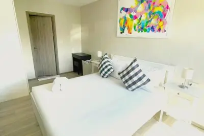 a white bed with pillows on it in a bedroom at B4 БАССЕЙН ВаТСАП669З582I976 in Nai Yang Beach