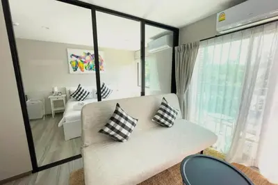 a living room with a couch and some windows at B4 БАССЕЙН ВаТСАП669З582I976 in Nai Yang Beach