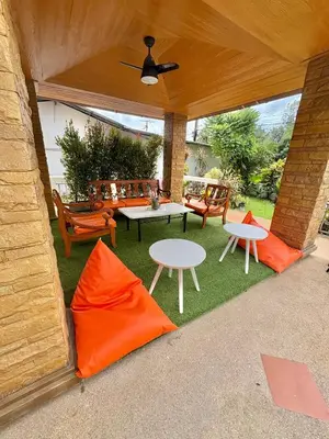 an outdoor patio with orange cushions and tables and chairs at Amazing 4BR pool villa near beach Bangtao in Ban Thalat Choeng Thale