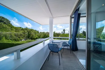 a balcony with two chairs and a table on it at Mai Khao Beach Luxury 7-bedroom villa 0 meters from the sea double infinity pool maid, outdoor wedding sea fishing in Mai Khao Beach