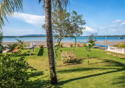 a palm tree with a chair and a view of the beach at Mai Khao Beach Luxury 7-bedroom villa 0 meters from the sea double infinity pool maid, outdoor wedding sea fishing in Mai Khao Beach