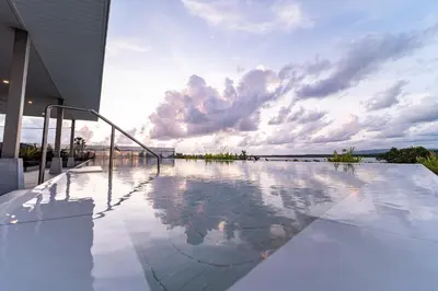 a swimming pool on the side of a house at Mai Khao Beach Luxury 7-bedroom villa 0 meters from the sea double infinity pool maid, outdoor wedding sea fishing in Mai Khao Beach