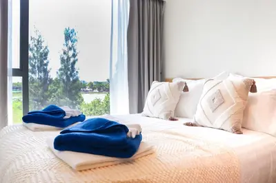 a bed with towels on it with a window at Lakeside Residences by NLA in Bang Tao Beach