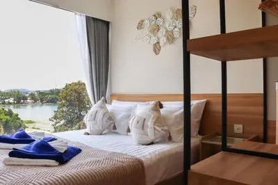 a bedroom with a bed with a view of a river at Lakeside Residences by NLA in Bang Tao Beach