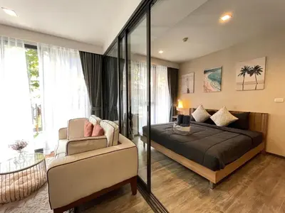 a bedroom with a bed and a chair in a room at The Deck Patong - Bangla in Patong Beach