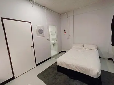 a white room with a bed and a bathroom at XX Bao Pathong Beach เบา ภูเก็ต หาดป่าตอง in Patong Beach