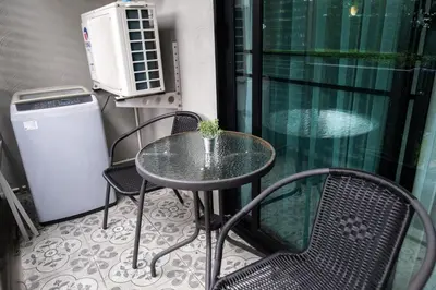 a table and chairs on a balcony with a small plant at G14 SuperKingSizeBed 1этаж тихая сторона in Nai Yang Beach