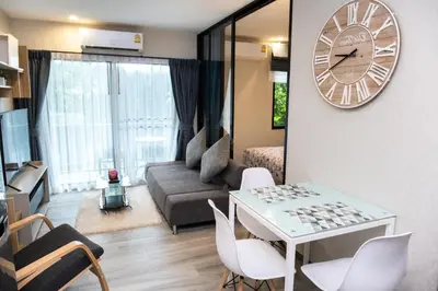 a living room with a table and a clock on the wall at G14 SuperKingSizeBed 1этаж тихая сторона in Nai Yang Beach