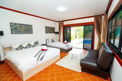 a bedroom with two beds and a couch and a chair at Lovely,Private 7 bedroom pool villa Kamala in Kamala Beach