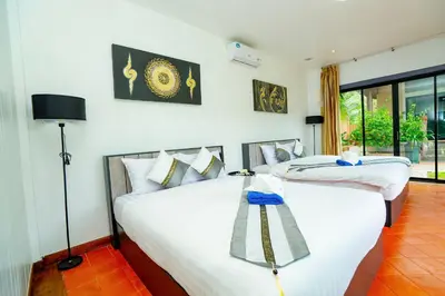 two twin beds in a room with a window at Lovely,Private 7 bedroom pool villa Kamala in Kamala Beach
