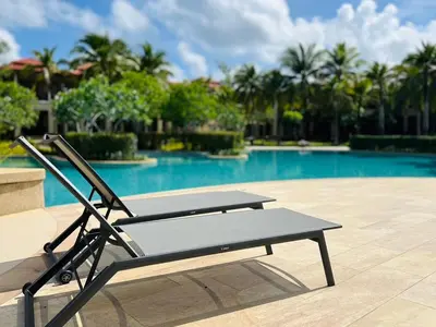 a bench sitting in front of a swimming pool at Laguna Village by RESAVA in Layan Beach