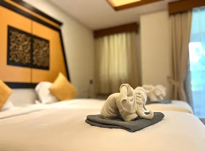 a pair of baby shoes sitting on a bed at Laguna Village by RESAVA in Layan Beach