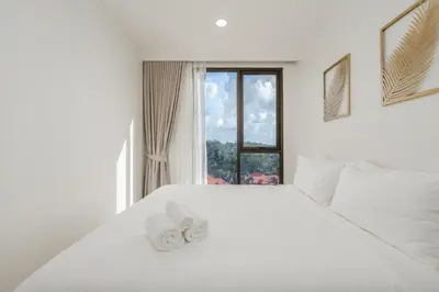 a white bed with two white towels on top of it at Идеальные апартаменты в Laguna Skypark in Phuket Town