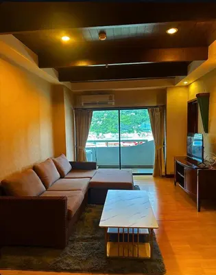 a living room with a couch and a table at Patong Tower Apartments By Tida in Patong Beach