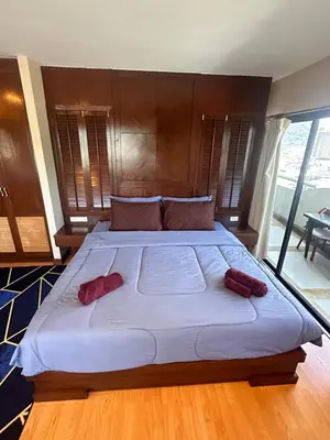 a large bed with two red pillows on it at Patong Tower Apartments By Tida in Patong Beach