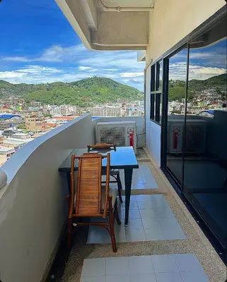 a table and chairs on a balcony with a view at Patong Tower Apartments By Tida in Patong Beach