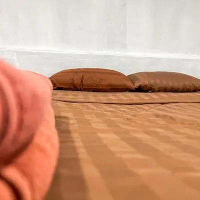 two brown pillows sitting on top of a bed at Happy House in Phi Phi Don