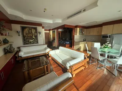 a living room with couches and a table and a kitchen at Patong Tower apartment with a great view in Patong Beach