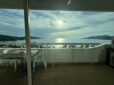 a balcony with a table and a view of the ocean at Patong Tower apartment with a great view in Patong Beach