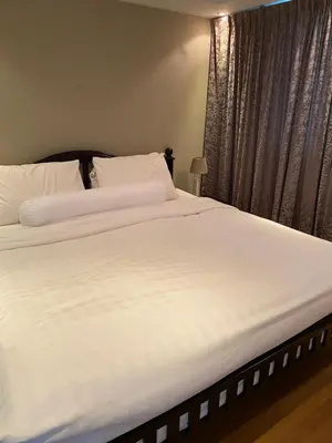 a large white bed in a bedroom with a window at Sea View One Bedroom Condo in Kata Beach in Kata Beach