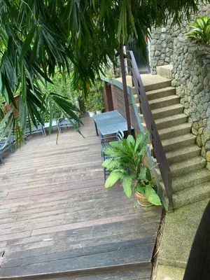 a wooden walkway with a bench and stairs with plants at Sea View One Bedroom Condo in Kata Beach in Kata Beach
