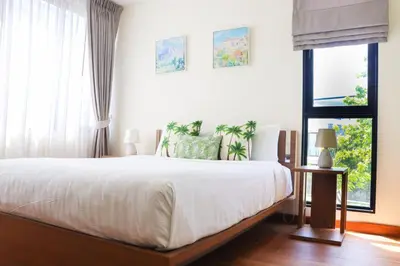 a bedroom with a large bed and a window at Big Garden Townhouse Laguna Park in Phuket Town