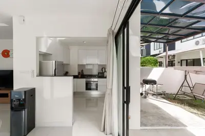 an open kitchen and dining room with a view of the backyard at Big Garden Townhouse Laguna Park in Phuket Town