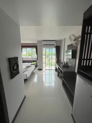 a large white room with a bed and a desk at Chollada Inn in Kamala Beach