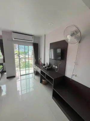 a living room with a desk and a fan at Chollada Inn in Kamala Beach