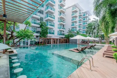 a swimming pool in front of a building at Fishermens Harbour Urban Resort - SHA Extra Plus in Patong Beach