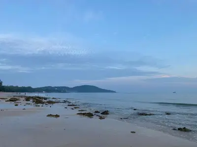 a beach with rocks and the ocean on a cloudy day at Green Tree Cottage 2 in Klong Muang Beach