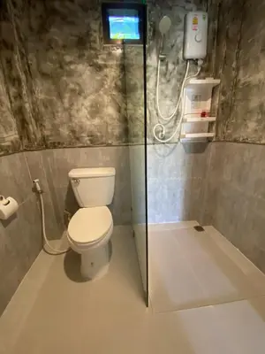 a bathroom with a toilet and a glass shower at Green Tree Cottage 2 in Klong Muang Beach